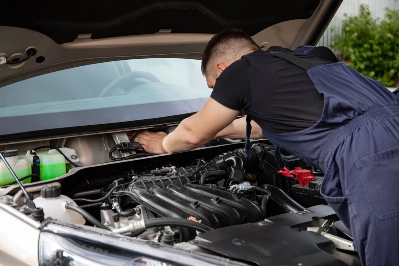 Technicien GTRACK installant un traceur GPS sur une voiture, à domicile en Île-de-France